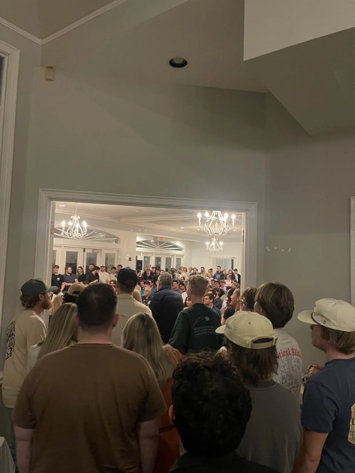 Overflow attendees line the hallways and doorways